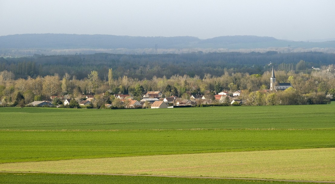Village et son clocher dans un paysage agricole