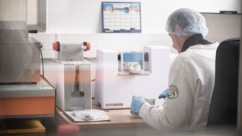 Un laborantin analyse un échantillon de lait. Voir le crédit et la légende sous l'image.