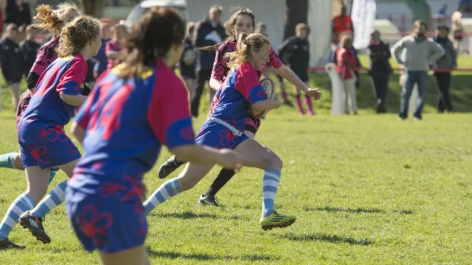 Des joueuses de rugby en pleine course.
