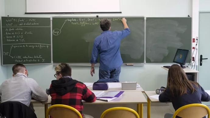 Un professeur et des élèves dans une salle de classe.