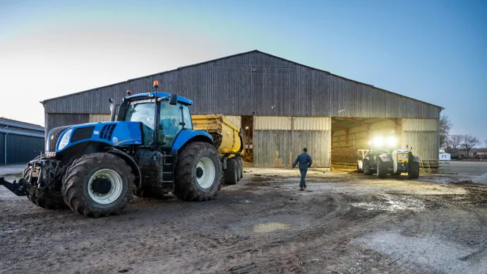 Tracteur dans la cour d'une exploitation agricole, voir crédit photo