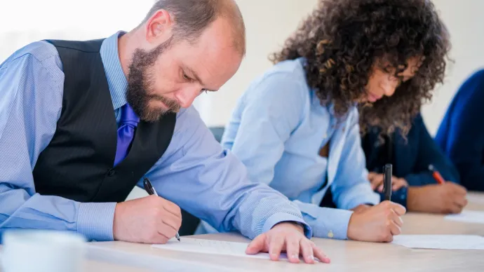 Des candidats en train passer un concours ou un examen, voir crédit photo
