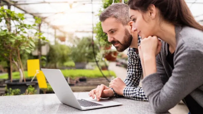 Deux personnes regardent un ordinateur. Voir le crédit sous l'image.