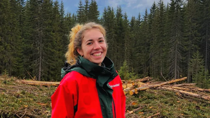 Julie Smith, étudiante agricole posant devant une forêt