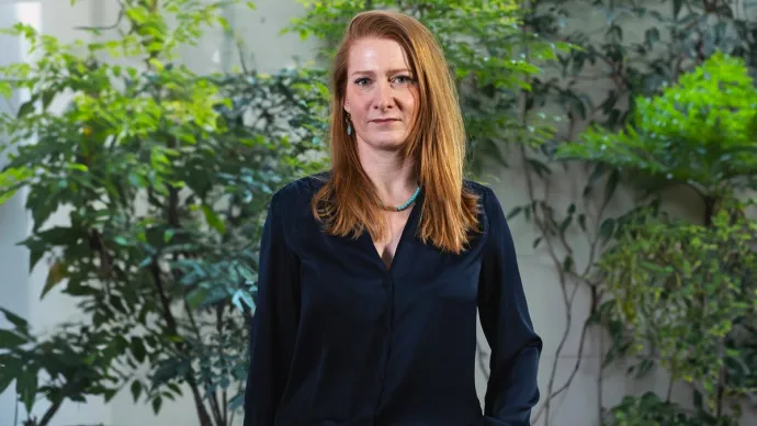 Emilie Tafournel posant devant un mur et des arbustes